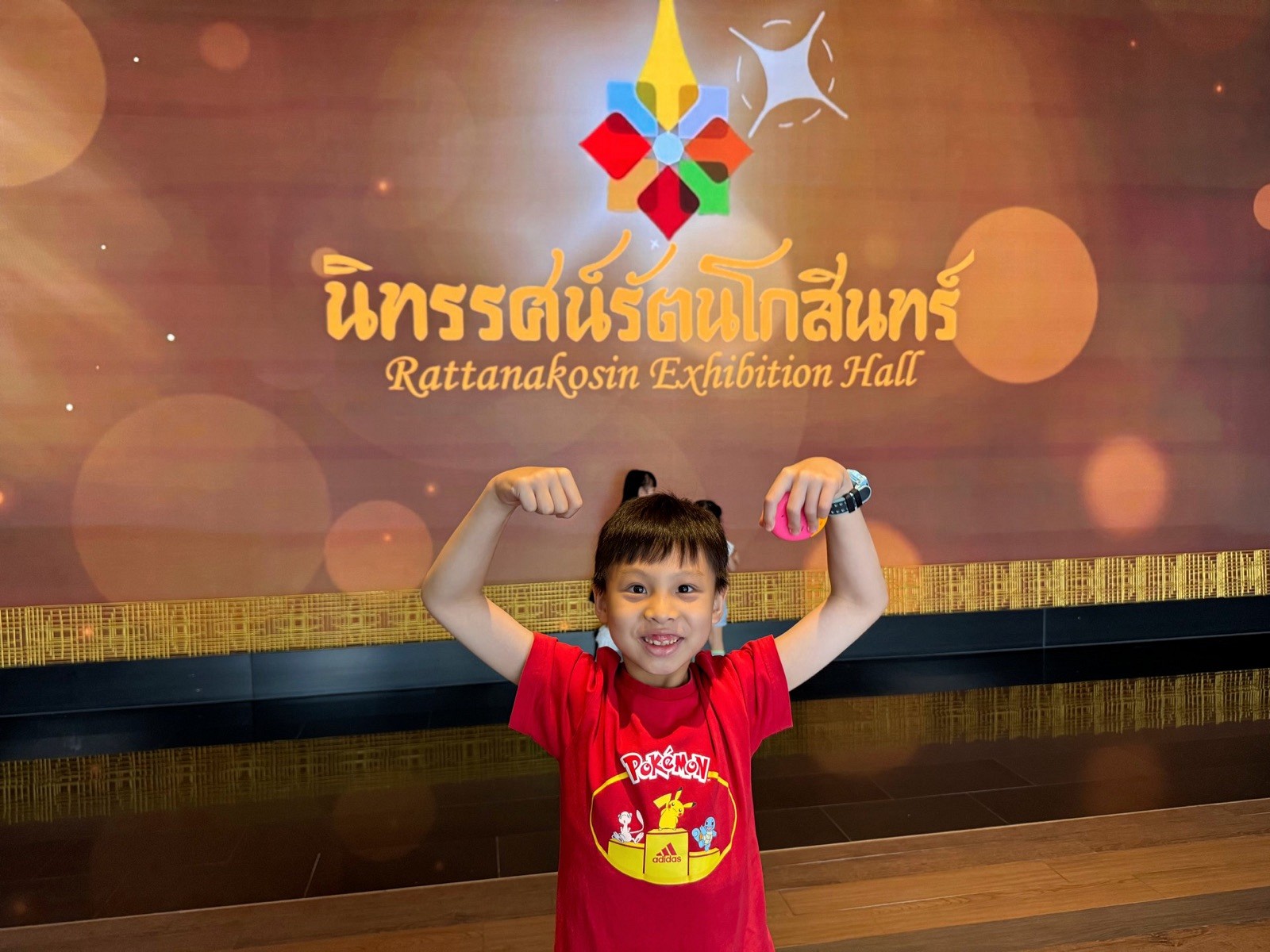 Child posing in front of the Rattanakosin Exhibition Hall sign