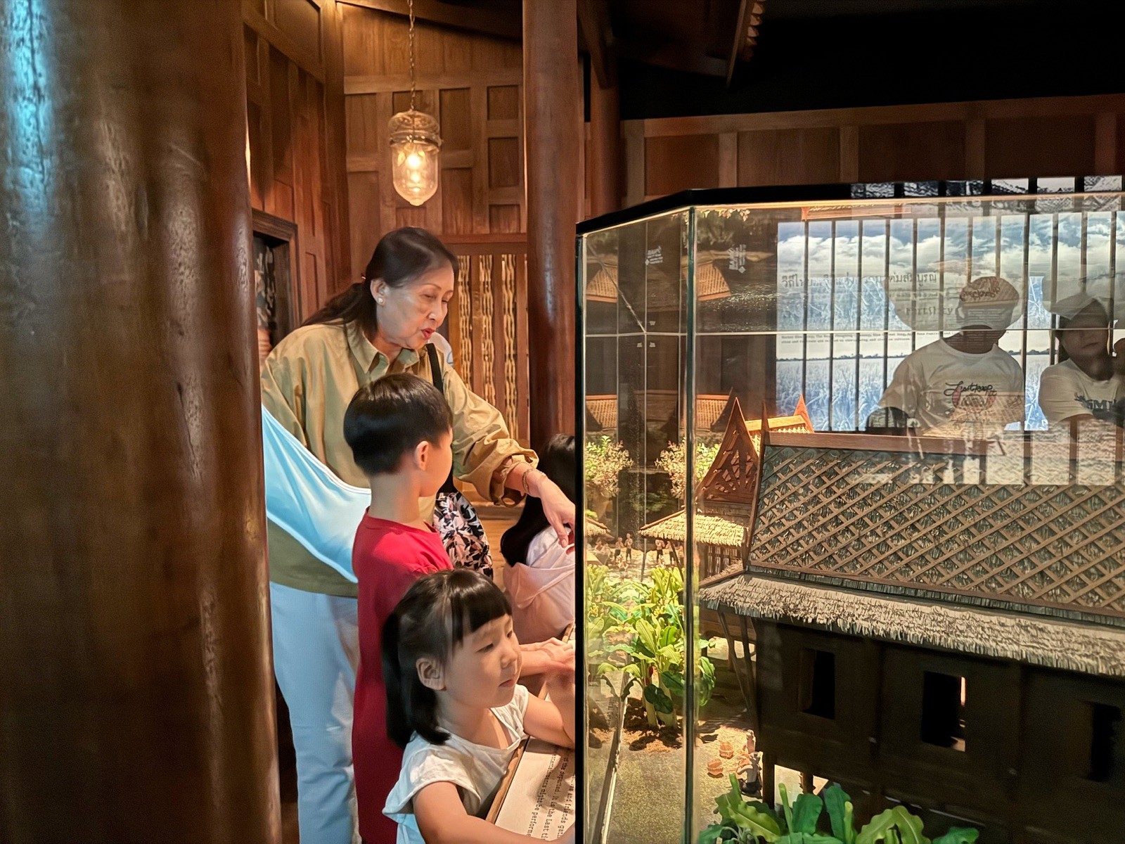 Children discovering a model of traditional Thai life at the exhibition