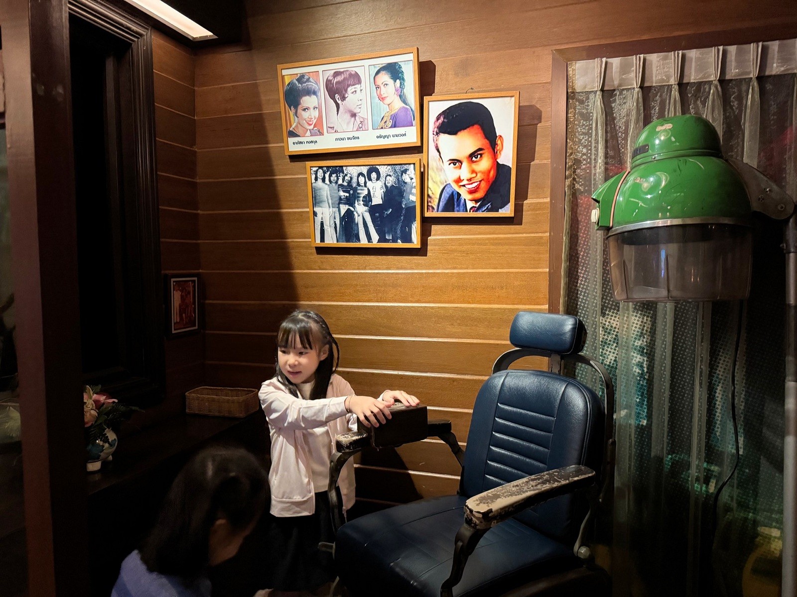 A child beside a vintage barber chair in the exhibition