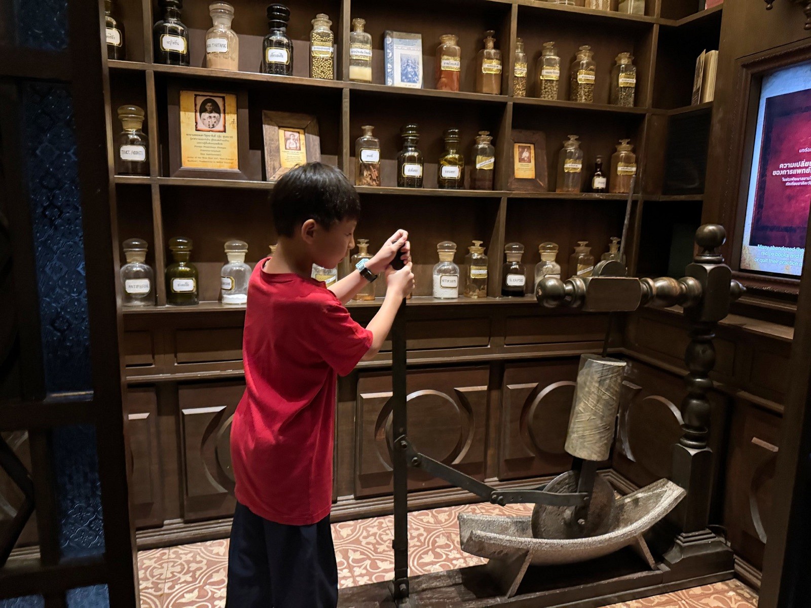 A child exploring a traditional shop display at Rattanakosin Exhibition Hall