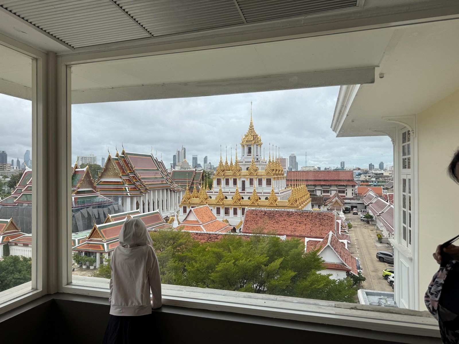 A child looking out towards Loha Prasat from Rattanakosin Exhibition Hall